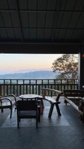 a patio with benches and a view of the ocean at ภูคำฮ้อมคลิฟฟ์ลอดจ์ แอนด์ โฮมสเตย์ Phu come home cliff Lodge & Homestay in Ban Phu Hi