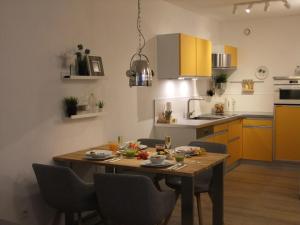 een keuken met een houten tafel met stoelen en een eetkamer bij Ferienwohnung mit Seeischt im Haus Frische Brise 05.10 in Cuxhaven