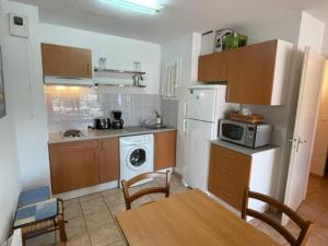 Il comprend une cuisine équipée d'un réfrigérateur blanc et d'une table. dans l'établissement Appartement Vieux-Boucau-les-Bains, 2 pièces, 6 personnes - FR-1-379-146, à Vieux-Boucau-les-Bains