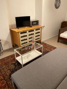 ein Wohnzimmer mit einem TV und einem Couchtisch in der Unterkunft Pleasant Loft Apartment In The Heart Of Tel-Aviv in Tel Aviv