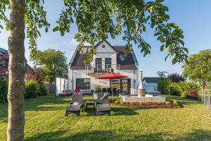 a house with chairs and a table in the yard at Luxus Ferien VILLA VIVALDI in Göhren-Lebbin +33 photos