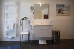 ein Bad mit einem Waschbecken und einem Spiegel in der Unterkunft Hohe Geest Whg. 6 in Cuxhaven
