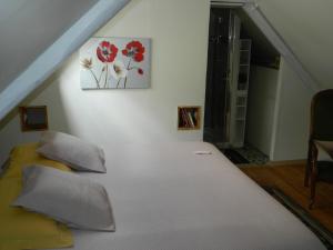 Penty La Houssaye في بونتيفي: غرفة نوم بسرير ابيض مع وسادتين