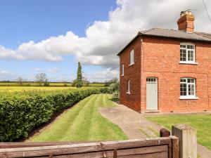 an old brick building next to a field at East Farm Cottage in Lincoln