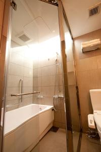 a bathroom with a shower and a tub and a sink at Citadines Central Shinjuku Tokyo in Tokyo