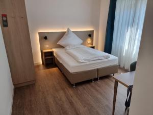 a bedroom with a bed with a large white pillow on it at Hotel zur Traube in Möglingen