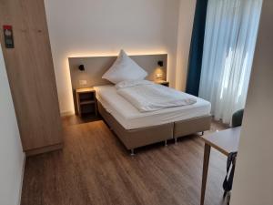 1 dormitorio con 1 cama con una gran almohada blanca en Hotel zur Traube, en Möglingen