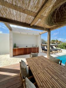 an outdoor dining area with a wooden table and chairs at Villa Ban Kas Curaçao in Jan Thiel