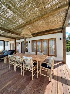 een houten eettafel en stoelen op een terras bij Villa Ban Kas Curaçao in Jan Thiel