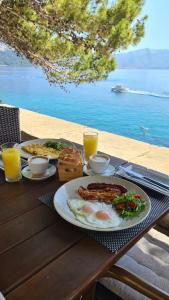 - une table avec des assiettes de petit-déjeuner et une vue sur l'eau dans l'établissement Stylish City View Apartment * Bellela *, à Korčula