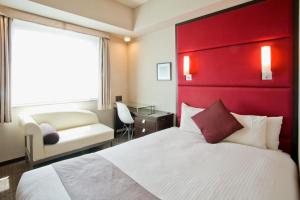 a hotel room with a bed and a red headboard at Citadines Central Shinjuku Tokyo in Tokyo