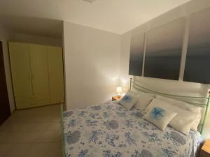 1 dormitorio con 1 cama con sábanas azules y blancas en Vento di Mare, en Muravera