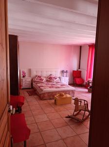 - une chambre avec un lit dans une pièce dotée de chaises rouges dans l'établissement Maison de tout vent, à Pierrefonds