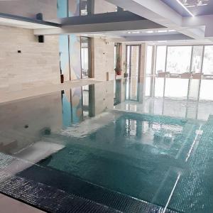 een zwembad in een gebouw met een zwembad bij Helena Apartments in Kopaonik