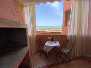 einen Tisch und Stühle in einem Zimmer mit Fenster in der Unterkunft Vento di Mare in Muravera