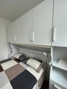 1 dormitorio con 1 cama con armarios blancos en The Small White House In Milan, en Milán