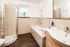 a bathroom with a tub and a sink and a shower at Apartment Bellaria in Santa Cristina Gherdëina