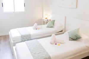 バレンシアにあるCabanyal Luxury Malvarrosa Beachの白い壁の客室内のベッド2台