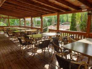 a row of tables and chairs on a wooden deck at Vila Tisa in Tismana