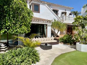 Casa con jardín y patio con sofá en Villa Turrion, en Marbella