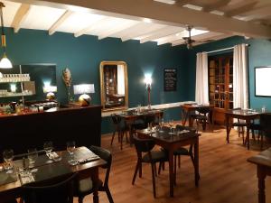 um restaurante com mesas e cadeiras num quarto em L'Auberge des Collines em Granges-Les-Beaumont