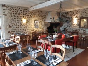 a restaurant with wooden tables and chairs in a room at L'Auberge des Collines in Granges-Les-Beaumont