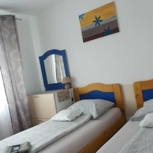 a bedroom with two beds and a mirror at Aliz Apartman in Nyíregyháza