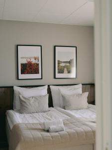 een slaapkamer met een bed met twee foto's aan de muur bij Siljansnäs Hotell in Siljansnäs