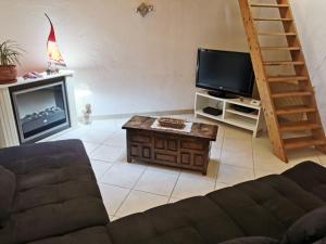 a living room with a couch and a tv at Maison de Village aux portes du verdon in Salernes