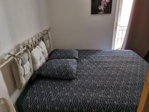 1 dormitorio con 1 cama con edredón blanco y negro en Maison de Village aux portes du verdon en Salernes