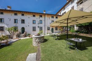 um pátio com uma mesa e um guarda-chuva num quintal em Agriturismo Borgo di Calmasino em Bardolino