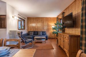 a living room with a blue couch and a tv at Villetta Campiglio in Madonna di Campiglio