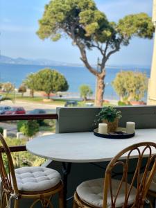 una mesa y sillas en un balcón con vistas al océano en Blue Vision, en Nea Makri