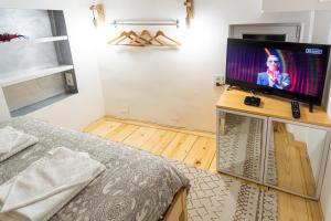 a bedroom with a flat screen tv on a table at City Passage Apartments in Belgrade