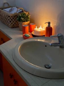 新馬克立的住宿－Blue Vision，浴室的盥洗盆和柜台上的蜡烛
