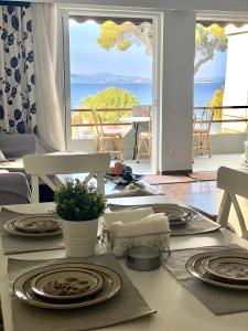 mesa de comedor con platos y vistas al océano en Blue Vision, en Nea Makri