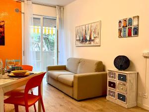 uma sala de estar com um sofá e uma mesa em Grazioso Appartamento con Piscina e Terrazza em Porto Santa Margherita di Caorle