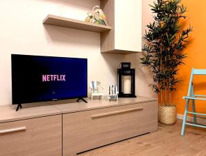uma televisão de ecrã plano em cima de uma cómoda em Grazioso Appartamento con Piscina e Terrazza em Porto Santa Margherita di Caorle