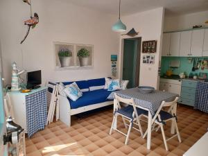 un soggiorno con un divano blu e un tavolo di Casa pappagallo a Calasetta Altre 8 foto