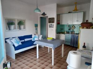 un soggiorno con un divano blu e un tavolo di Casa pappagallo a Calasetta