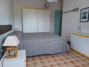 una camera da letto con un letto e un tavolo con una lampada di Casa pappagallo a Calasetta