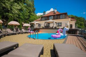 basen przed domem z różowym łabędziem w środku w obiekcie Hotel Łaziska w mieście Czchów