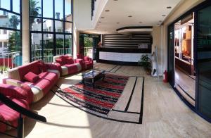 a living room with red couches and a rug at HİMEROS BEACH HOTEL in Kemer