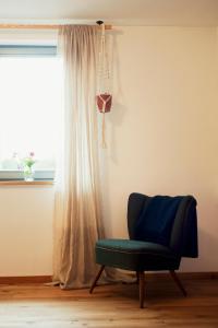 a blue chair in a room with a window at Gasthaus Canow in Wustrow +33 photos