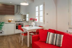 - un salon avec un canapé rouge et une table dans l'établissement 32 nero - Florence Apartment San Niccolò, à Florence