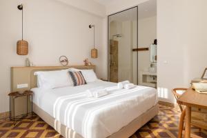 a bedroom with a large white bed and a desk at Casa Natura in Rhodes Town