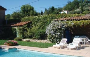 een zwembad met stoelen en een heg met bloemen bij Stunning Home In Chteauneuf De Grasse With Outdoor Swimming Pool in Opio
