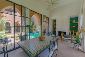 une salle à manger avec une table, des chaises et une cheminée dans l'établissement Residence Dar Lamia Marrakech, à Dar Caïd Layadi