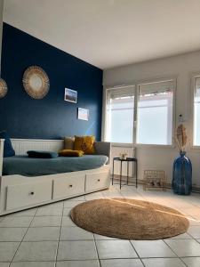 1 dormitorio con cama y pared azul en Jeter l’ancre - studio, en Calais