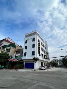 ein weißes Gebäude an der Ecke einer Straße in der Unterkunft Phú Quý Hotel in Thanh Hóa